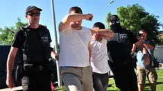 Dua dari 8 perwira militer pendukung kudeta di Turki dikawal polisi Yunani di kota Alexandroupoli, Minggu (17/7). 8 pria yang terbang dengan helikopter militer Turki itu ditahan petugas keamanan Yunani karena masuk secara ilegal. (Sakis MITROLIDIS/AFP)