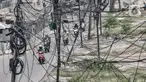 Kendaraan melintas dekat instalasi kabel yang semrawut di Jalan Raya Bekasi, Cakung, Jakarta, Rabu (30/9/2020). Minimnya perawatan pascapembebasan lahan permukiman untuk proyek Tol Dalam Kota membuat jaringan kabel listrik di sepanjang jalan tersebut semrawut. (merdeka.com/Iqbal S. Nugroho)