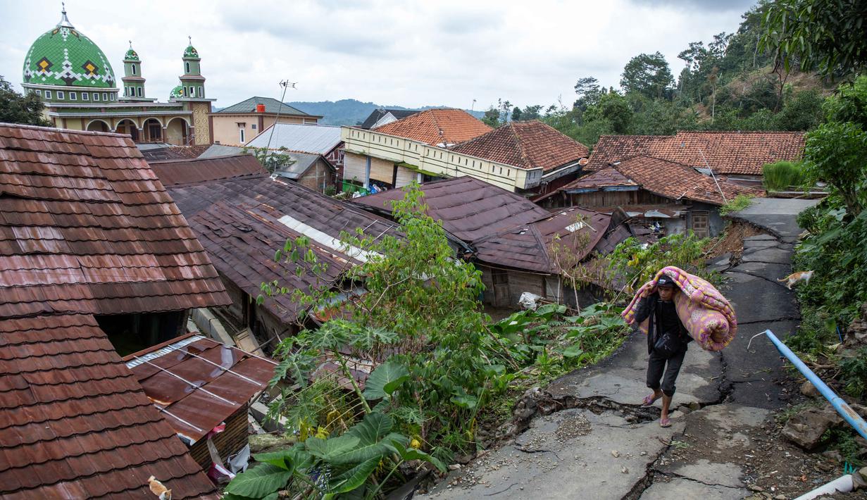 Dari jumlah tersebut, terdapat 220 warga lanjut usia (lansia), 3 ibu hamil, 3 ibu menyusui, 179 anak-anak, 40 balita, 65 batita, 1.049 remaja, dan 894 dewasa. Tampak dalam foto, Seorang pria menyelamatkan barang-barangnya setelah pergerakan tanah melanda permukiman mereka di desa Padasari, Tegal, Jawa Tengah, Senin 9 Februari 2026. (DEVI RAHMAN/AFP)