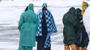 Petugas medis menyambut kedatangan warga yang turun dari pesawat militer di sebuah bandara luar Tyumen, Rusia, Rabu (5/2/2020). Seluruh warga yang dievakuasi dari Wuhan menyusul wabah virus corona tersebut akan dikarantina selama dua minggu di Siberia. (AP Photo/Maxim Slutsky)