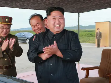 Pemimpin Korea Utara, Kim Jong-Un merayakan uji coba peluncuran rudal balistik Hwasong-12 di lokasi yang tidak diketahui pada foto yang dirilis Sabtu (16/9). Kim Jong-Un bersumpah akan menyempurnakan kekuatan nuklir negaranya. (KCNA/KNS via AP)