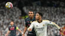 Gelandang Real Madrid, Jude Bellingham, berduel dengan bek Man City, Manuel Akanji, dalam laga leg pertama perempat final Liga Champions di Santiago Bernabeu, Rabu (10/4/2024) dini hari WIB. Real Madrid dan Man City bermain imbang 3-3. (JAVIER SORIANO / AFP)