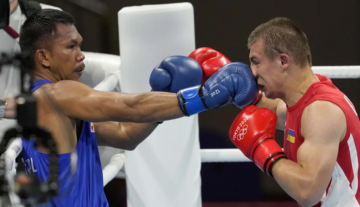 Petinju asal Filipina,Eumir Marcial (kiri) melepaskan pukulan ke wajah Oleksandr Khyzhniak, dari Ukraina, dalam pertandingan tinju semifinal kelas menengah 69-75kg pada Olimpiade Tokyo 2020,  Kamis (5/8/2021). (Foto: AP/Themba Hadebe)