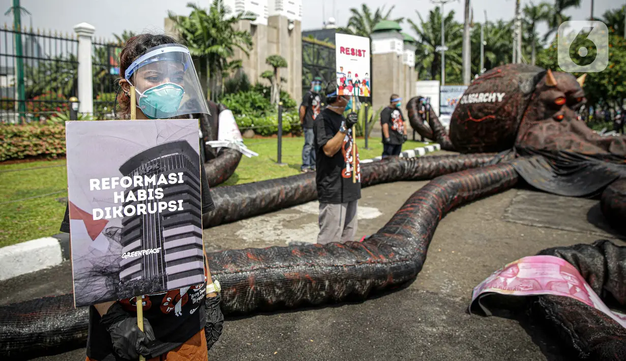 Aktivis Greenpeace menggelar aksi di depan Gedung DPR RI, Jakarta, Selasa (5/10/2021). Dalam aksinya, mereka membawa gurita raksasa sebagai simbol oligarki serta menyerukan kepada pemerintah agar serius mengatasi pandemi dan memberantas korupsi energi. (Liputan6.com/Faizal Fanani)