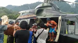 Warga mengevakuasi Heriani yang akan melahirkan saat tiba menggunakan helikopter di Dusun Air Teh, Sulawesi Tengah, Sabtu (27/7/2019). Evakuasi berawal saat Tim Penerbad menerima perintah untuk melakukan dorongan logistik bagi pasukan Satgas Tindak. (Liputan6.com/HO/Satgas TNI-Tinombala)