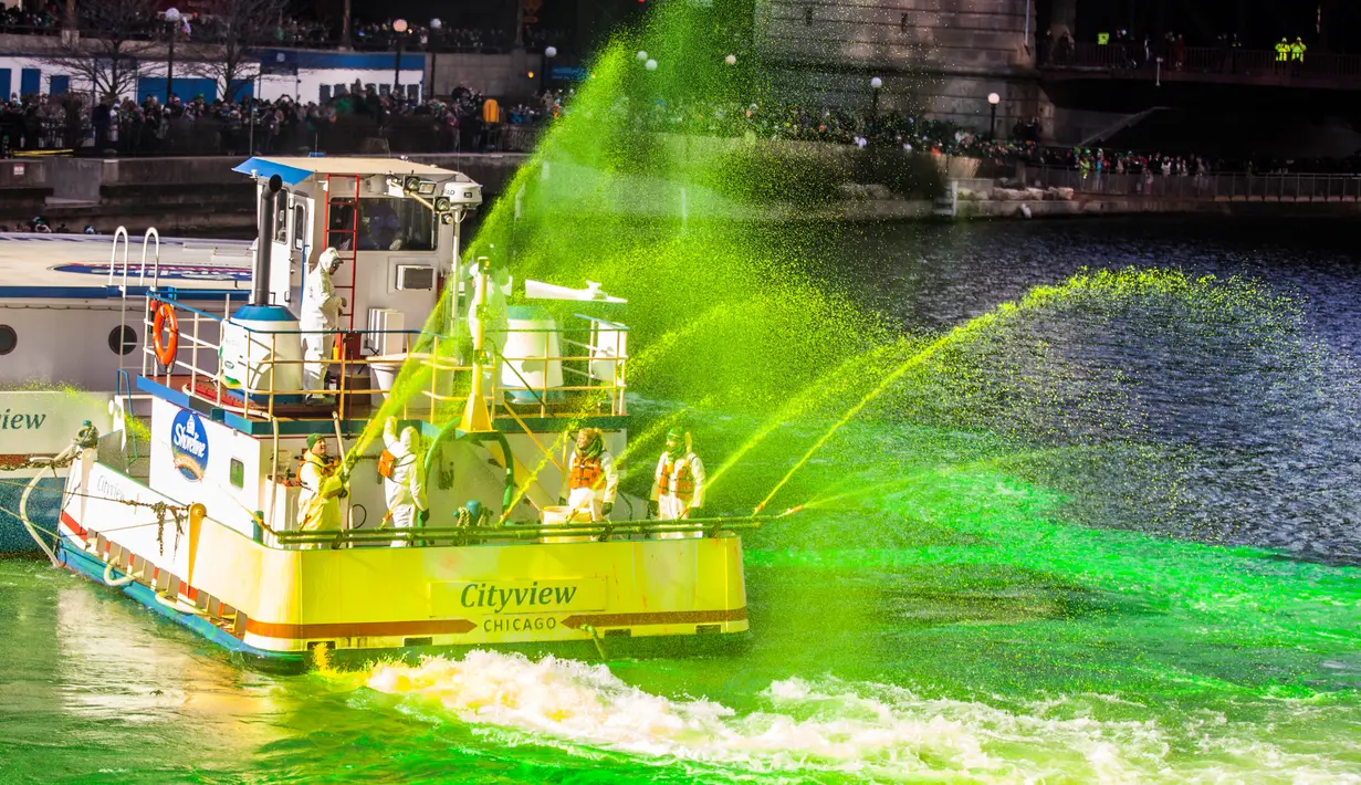 Petugas menggunakan kapal untuk menyemprotkan pewarna  hijau khusus ke sungai Chicago, AS selama perayaan St. Patrick's Day, 11 Maret 2017. Sungai itu setiap tahun mengalami perubahan warna demi memikat wisatawan. (Maria Cardona /Chicago Tribune via AP)