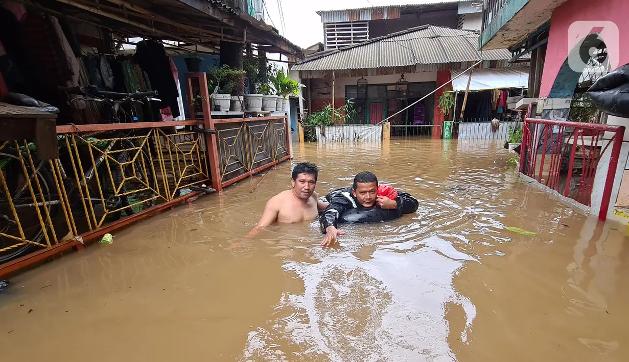 Warga menaiki ban saat menyusuri banjir di kawasan pemukiman Jalan Bango, Pondok Labu, Jakarta Selatan, Sabtu (20/2/2021). Banjir akibat luapan Kali Krukut yang melanda sejak semalam menyebabkan pemukiman tergenang hingga dua meter. (merdeka.com/Arie Basuki)