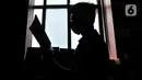 Pekerja membaca buku di sela bertugas menjaga toko JakBook, Pasar Kenari, Jakarta, Kamis (4/2/2021). Menurut salah satu pekerja, sebanyak 50 persen dari total buku koleksi JakBook terpaksa dikembalikan ke penerbit akibat merosotnya penjualan. (merdeka.com/Iqbal S. Nugroho)