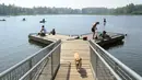 Sejumlah warga beraktivitas di Danau DeLong di Anchorage, Alaska (5/7/2019). Warga Anchorage dan kota-kota pusat selatan lainnya menyelesaikan minggu kelima suhu di atas normal, termasuk rekor tinggi 90 derajat (32,22 Celsius) pada Kamis, 4 Juli, di kota terbesar tersebut. (AP Photo/Anne Raup)