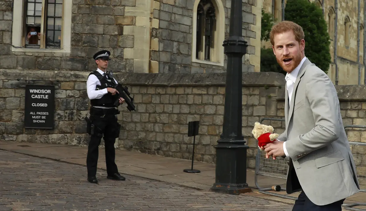Pangeran Inggris kembali usai menyapa orang-orang di luar Kastil Windsor, Inggris, Jumat (18/5). Pangeran Harry dan Meghan Markle akan menikah di Kastil Windsor. (Odd ANDERSEN/AFP)
