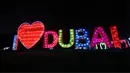 Instalasi lampu bertuliskan I Love Dubai di Dubai Garden Glow, Dubai, Uni Emirat Arab, 1 November 2021. Instalasi tersebut dibuat dari lebih satu juta bohlam penghemat energi dan kain bercahaya daur ulang karya seniman seluruh dunia. (GIUSEPPE CACACE/AFP)