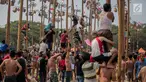 Warga mengikuti lomba Panjat Pinang Kolosal dalam rangka merayakan HUT ke-74 Kemerdekaan RI di Pantai Karnaval Ancol, Jakarta, Senin (17/8/2019). Sebanyak 174 batang pinang dengan beragam hadiah disediakan dalam lomba yang diikuti ratusan warga itu. (Liputan6.com/Faizal Fanani)