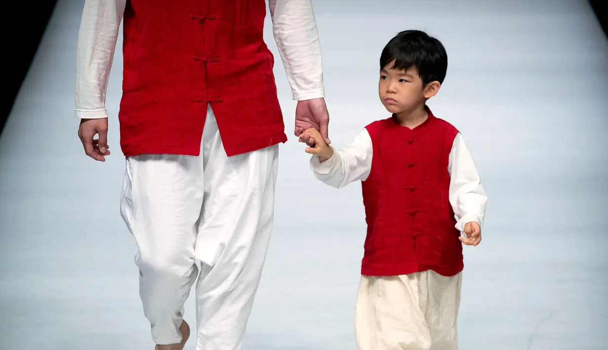 Model cilik berjalan di atas catwalk mengenakan koleksi busana orang tua dan anak YIAN karya Lu Enhua selama China Fashion Week di Beijing, Sabtu 1 April 2017. (AP Photo / Mark Schiefelbein)