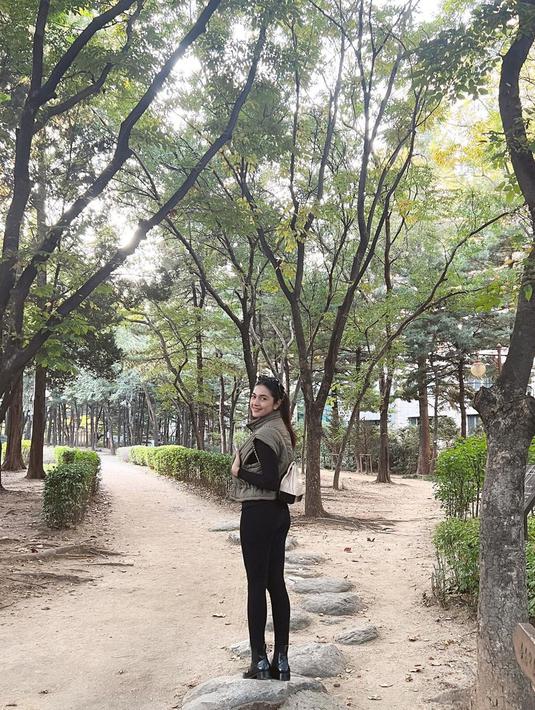 Gaya OOTD simpel juga dipilih Nabila saat jalan-jalan ke Dosan Park. Ia kembali memakai jaket rompi warna hijau army dengan inner lengan panjang. Aktris yang hobi berkuda itu memadukannya dengan celana panjang hitam, sepatu boots warna senada dan mini bag putih. (Liputan6.com/IG/@nsyakieb85)