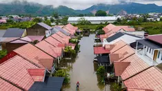 Foto udara menunjukkan seorang pria melintasi banjir setelah hujan deras di permukiman Darul Imarah di pinggiran Banda Aceh pada Kamis 27 November 2025. Curah hujan tinggi yang dipicu siklon tropis menyebabkan sejumlah wilayah di Aceh Besar, termasuk Darul Imarah, terendam banjir. (CHAIDEER MAHYUDDIN/AFP)