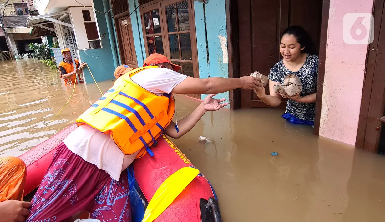 Petugas PPSU memberi bantuan nasi bungkus kepada warga yang bertahan saat banjir di kawasan pemukiman Jalan Bango, Pondok Labu, Jakarta Selatan, Sabtu (20/2/2021). Banjir akibat luapan Kali Krukut yang melanda sejak semalam menyebabkan pemukiman tergenang hingga dua meter. (merdeka.com/Arie Basuki)