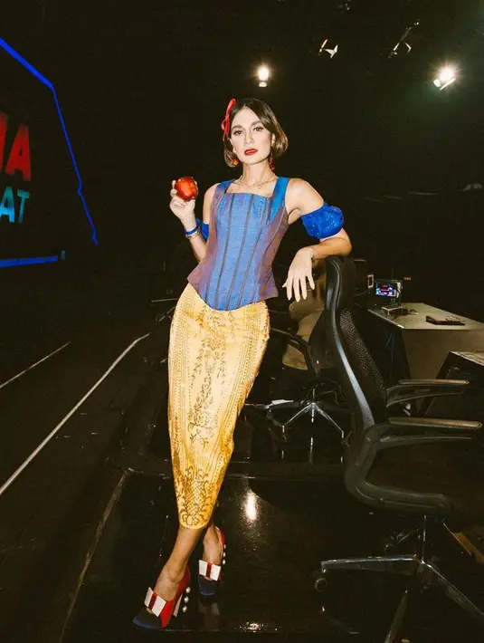Luna Maya juga pernah mengenakan kostum Snow White dengan atasan biru tanpa lengan dipadukan skirt bermotif warna kuning. [@lunamaya]