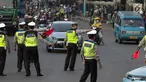 Petugas polisi lalu lintas memberi arahan kepada pengguna mobil saat pemberlakuan sistem ganjil genap di pintu masuk Gardu Tol Cibubur 2, Jakarta, Senin (16/4). (Liputan6.com/Faizal Fanani)
