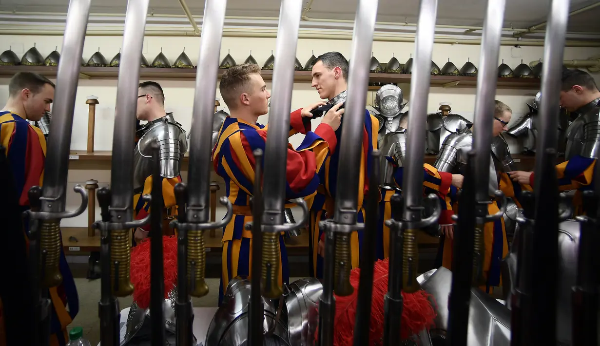 Pasukan Pengawal Swiss berdandan sebelum menghadiri upacara tahunan di Kota Vatikan (6/5). Swiss Guard adalah pasukan yang berasal dari Swiss namun mengabdikan diri kepada negara lain. (AFP/Filippo Monteforte)