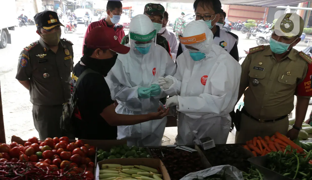 Petugas medis Gugus Tugas Kabupaten Bogor melakukan swab test dan rapid test kepada pedagang Pasar Cileungsi, Kabupaten Bogor, Jawa Barat, Selasa (16/6/2020). Sebelumnya, Pasar Cileungsi sempat menjadi klaster penyebaran COVID-19. (merdeka.com/Imam Buhori)