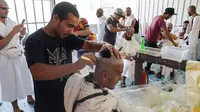 Jemaah haji mencukur rambut kepala atau tahalul usai melaksanakan lempar jumrah, Mina, Arab Saudi, Minggu (11/8/2019). Tahalul termasuk ke dalam serangkaian ibadah haji. (FETHI BELAID/AFP)