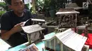 Perajin, Inoe Farhand menyelesaikan pembuatan miniatur jam dari pelepah pisang di Pamulang, Tangerang Selatan, Kamis (10/1). Kerajinan tangan buatan  Inoe dijual dengan harga antara Rp 500 ribu hingga Rp 2 juta. (Merdeka.com/Arie Basuki)