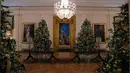 Sejumlah pohon cemara yang didekorasi untuk perayaan Natal terlihat selama pratinjau dekorasi liburan 2018 di Gedung Putih, Washington DC, Senin (26/11). Tema dekorasi yang diangkat tahun 2018 ini adalah 'American Treasures'. (NICHOLAS KAMM / AFP)