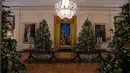 Sejumlah pohon cemara yang didekorasi untuk perayaan Natal terlihat selama pratinjau dekorasi liburan 2018 di Gedung Putih, Washington DC, Senin (26/11). Tema dekorasi yang diangkat tahun 2018 ini adalah 'American Treasures'. (NICHOLAS KAMM / AFP)