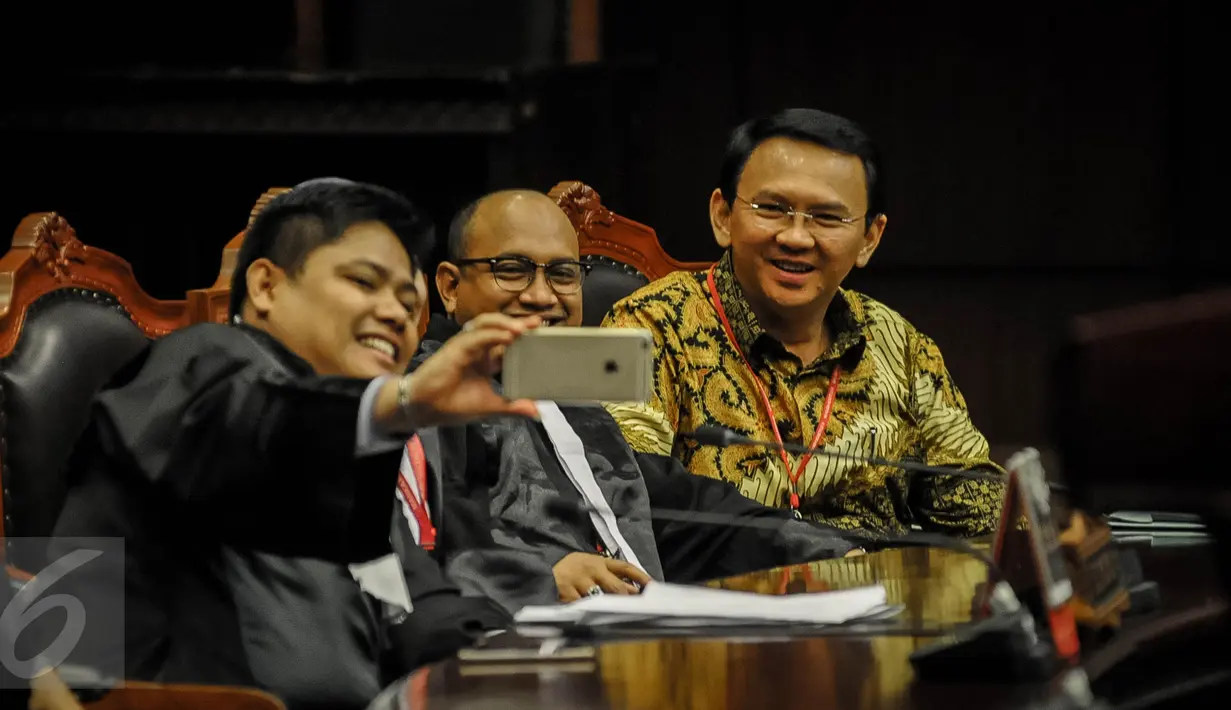 Gubernur DKI Basuki Tjahaja Purnama (Ahok) berfoto sebelum sidang lanjutan sidang uji materi UU Pilkada di Mahkamah Konstitusi, Jakarta,  Senin (26/9). Sidang beragenda mendengarkan keterangan ahli yang dihadirkan pemohon. (Liputan6.com/Faizal Fanani)