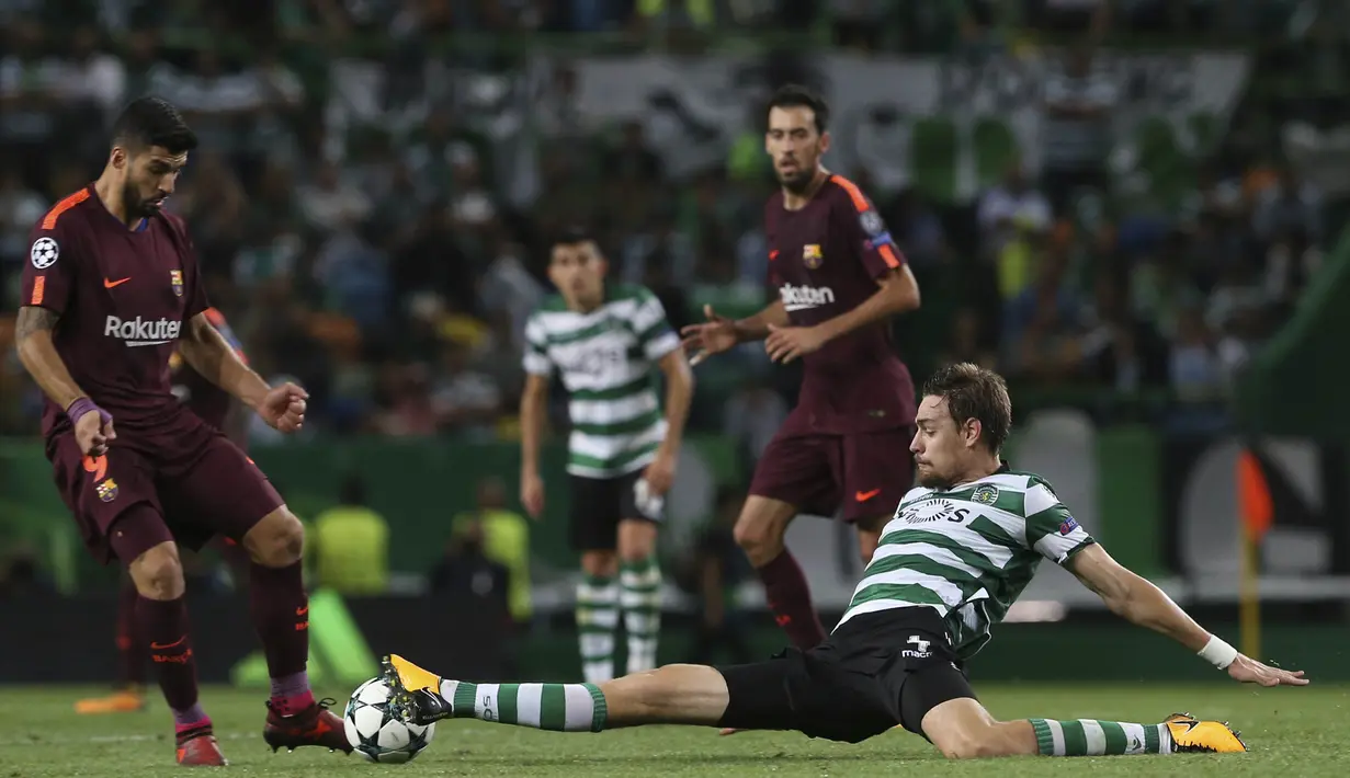 Striker Barcelona, Luis Suarez, menghindari tekel bek Sporting Lisbon, Sebastian Coates, pada laga Liga Champions di Stadion Alvalade, Lisbon, Rabu (27/9/2017). Sporting kalah 0-1 dari Barcelona. (AFP/Armando Franca)