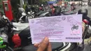 Petugas menunjukkan karcis parkir di Jalan Sabang, Jakarta, Jumat (15/12). Berakhirnya masa kontrak PT Mata Elang Biru selaku pengelola mesin parkir menyebabkan sistem penarikan biaya parkir dilakukan secara manual. (Liputan6.com/Immanuel Antonius)