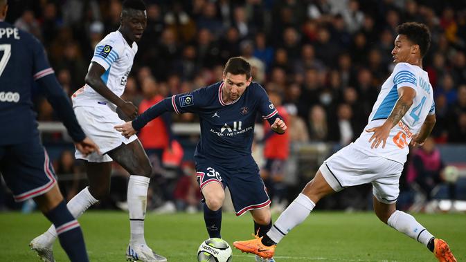 Penyerang Paris Saint-Germain (PSG) Lionel Messi (tengah) berebut bola dengan bek  Olympique Marseille Boubacar Kamara pada laga Liga Prancis pekan ke-32 di Parc des Princes, Senin (18/4/2022) dini hari WIB. PSG vs Marseille berakhir dengan skor 2-1. (FRANCK FIFE / AFP)