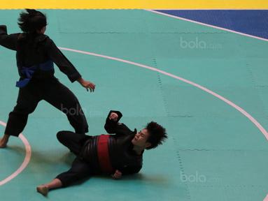 Octaviani Nirmalasari (kanan) mencoba menjatuhnkan lawannya asal Laos, Olahthai Sounthavong pada semifinal Test Event Pencak Silat 2018 di Padepokan Silat TMII, Jakarta, (12/2/2018). Oktaviani menang 5-0. (Bola.com/Nick Hanoatubun)