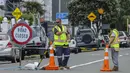 Sejumlah media lokal melaporkan beberapa helikopter dikerahkan untuk mendukung operasi pencarian dan penyelamatan yang masih berlangsung. Tampak dalam foto, petugas darurat menutup jalan setelah tanah longsor sementara pencarian sedang dilakukan oleh layanan darurat setempat untuk orang hilang di Gunung Maunganui, Tauranga, Selandia Baru pada Kamis 22 Januari 2026. (DJ MILLS/AFP)