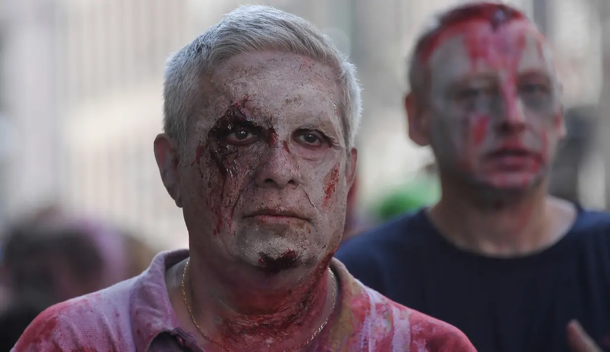 Warga berjalan kaki dan berdandan bak zombie saat berpartisipasi dalam acara Zombie Walk di kota Strasbourg, Prancis, 14 September 2019. Acara yang digelar dalam rangka Festival Film Fantasi Eropa ke-12 ini berlangsung dari  14 hingga 23 September. (FREDERICK FLORIN / AFP)