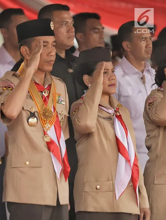 Presiden Joko Widodo bersama Ibu Negara Iriana memberi hormat saat mengikuti acara menghadiri perayaan hari jadi Pramuka yang ke-57 di Lapangan Gajah Mada, Wiladatika, Cibubur, Jakarta, Selasa (14/8). (Liputan6.com/Faizal Fanani)