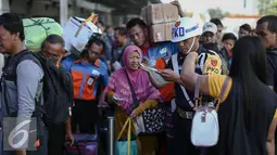 Petugas PKD memeriksa tiket calon penumpang kereta api yang antre memasuki peron di Stasiun Pasar Senen, Jakarta, Minggu (3/7). H-3 Lebaran, Stasiun Pasar Senen sudah memberangkatkan 11.905 pemudik dengan dengan 16 kereta api. (Liputan6.com/Faizal Fanani)