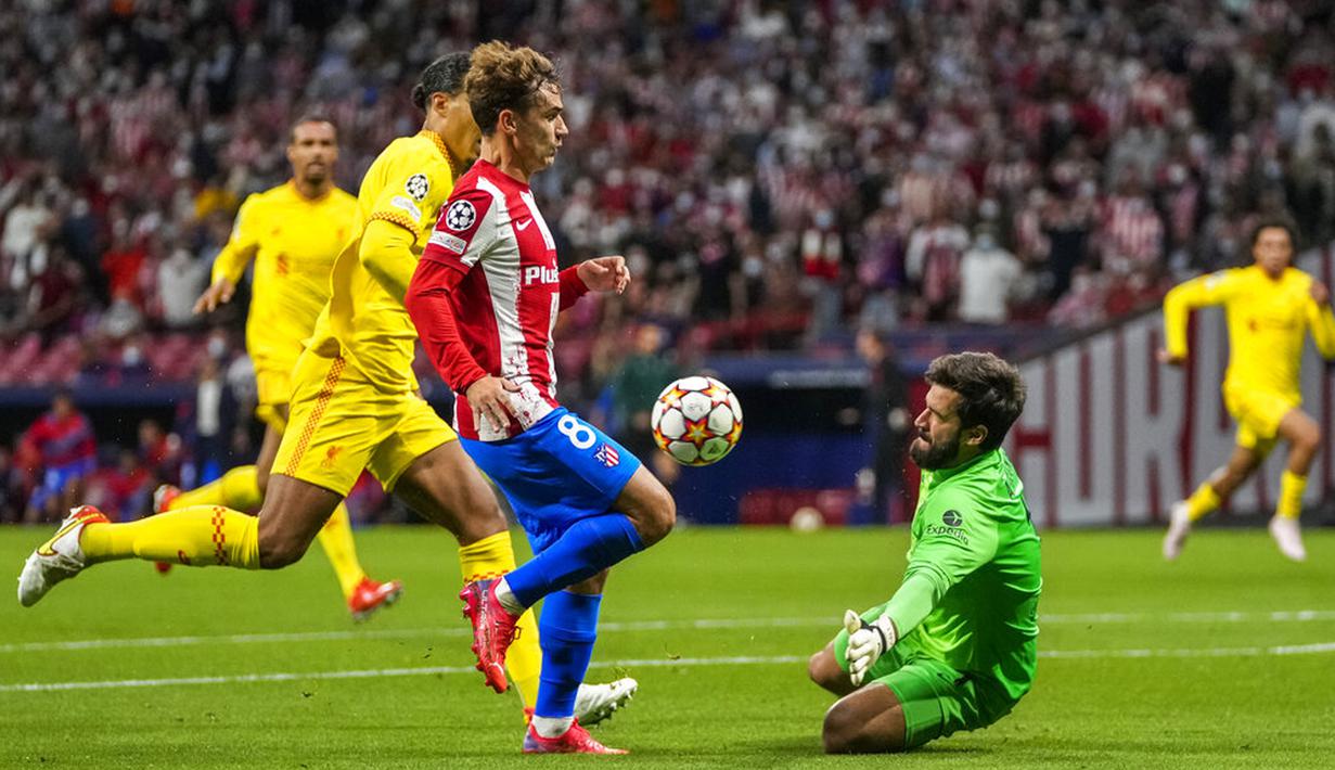 Pemain Atletico Madrid Antoine Griezmann berhadapan dengan penjaga gawang Liverpool Alisson (kanan) pada pertandingan sepak bola Grup B Liga Champions di Stadion Wanda Metropolitano, Madrid, Spanyol, Selasa (19/10/2021). Liverpool menang 3-2. (AP Photo/Manu Fernandez)
