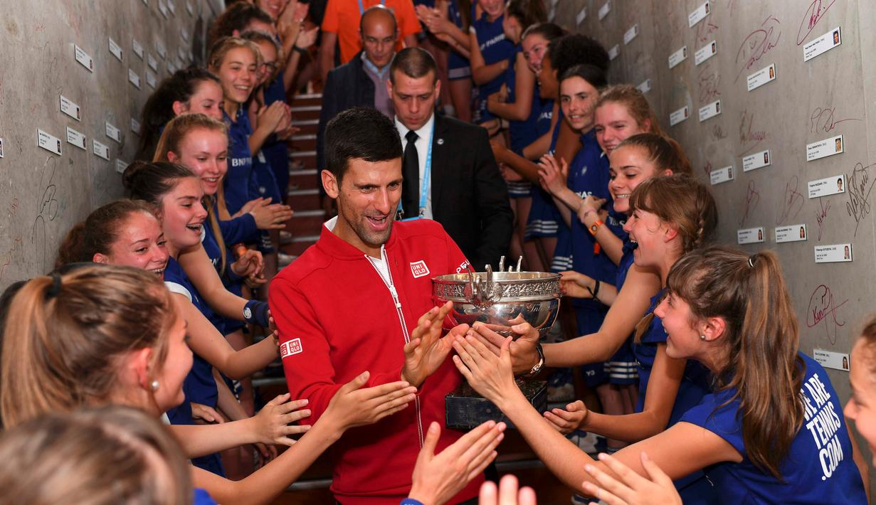 Petenis Serbia, Novak Djokovic, disambut ball girls setelah menjadi juara Prancis Terbuka 2016 dengan mengalahkan Andy Murray dalam final di Roland Garros, Paris, (5/6/2016). (Reuters/Nicolas Gouhier/FFT/Pool)