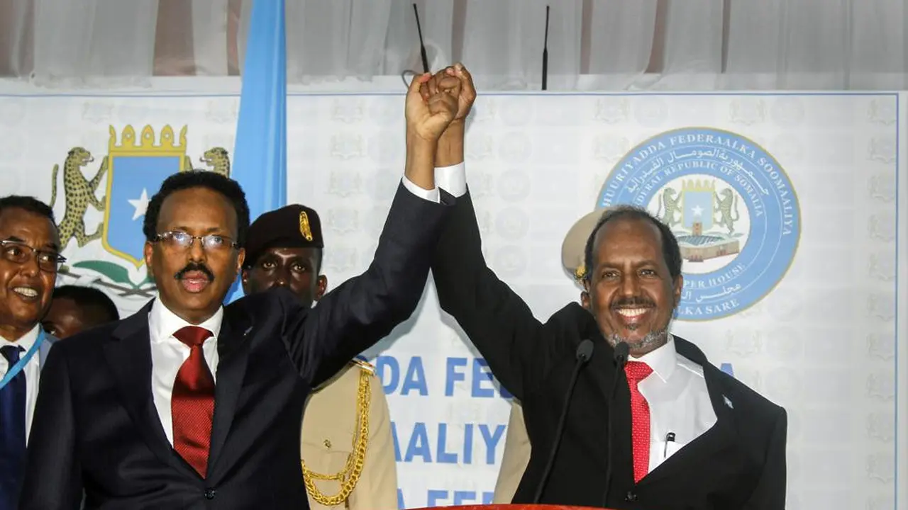 Hassan Sheikh Mohamud (kanan), menang pemilu dengan pemimpin petahana Mohamed Abdullahi Mohamed (kiri), di kamp militer Halane di Mogadishu, Somalia, Minggu, 15 Mei 2022. (AP Photo/Farah Abdi Warsameh)