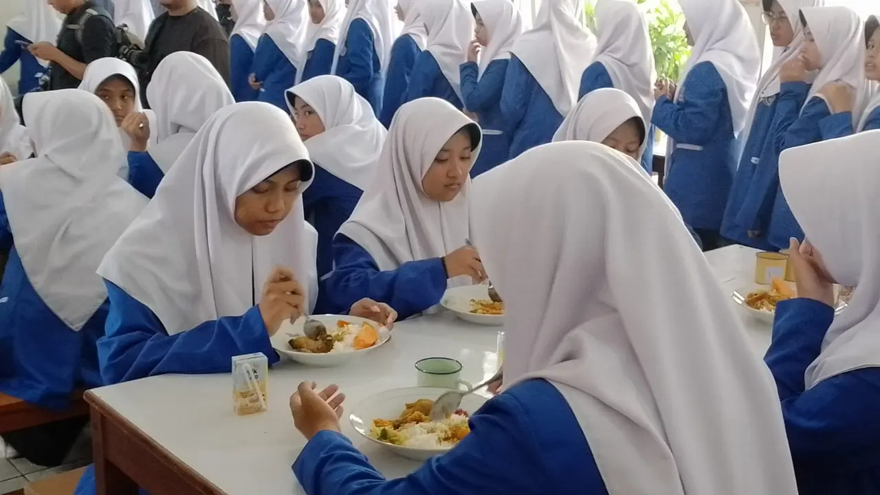 Para santri putri Pesantren Darul Arqom, Garut, Jawa Barat tengah menyantap makan dalam uji coba Makan Bergizi Gratis (MBG) yang digelar pemerintah. (Liputan6.com/Jayadi Supriadin)