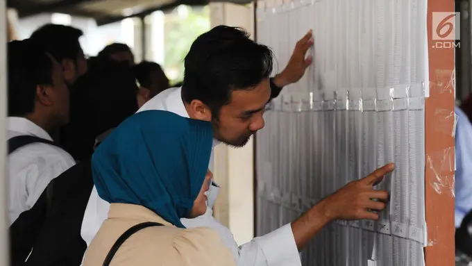 Peserta tes seleksi CPNS Kemenkumham mengecek no pendaftaran di gedung BKN, Jakarta, Senin (11/9). Pada 2017, tercatat 1.116.138 pelamar CPNS mendaftar di lingkungan Kemenkumham. (Liputan6.com/Helmi Fithriansyah)
