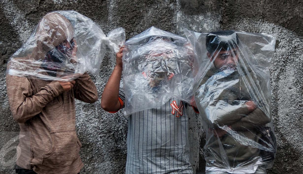 Warga memakai plastik sebagai alat bantu untuk bernafas saat kebakaran melanda Pasar Senen, Jakarta, Kamis (19/1). Petugas Damkar mengerahkan sedikitnya 50 unit mobil pemadam untuk mengatasi kebakaran tersebut. (Liputan6.com/Gempur M Surya)