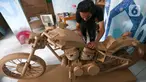 Perajin menyelesaikan pembuatan motor dari kardus di Workshop Bumi Kardus, Depok, Jawa Barat, Jumat (15/7/2022). Kerajinan berbahan baku kardus tersebut dijual dengan harga Rp 400 ribu hingga Rp 60 juta tergantung tingkat kesulitan dan ukuran. (Liputan6.com/Herman Zakharia)