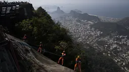 Kru pembersih Brasil melakukan panjat tebing di bawah bayang-bayang salah satu situs paling terkenal di dunia: Patung Kristus Sang Penebus di Rio de Janeiro. (AP Photo/Bruna Prado)