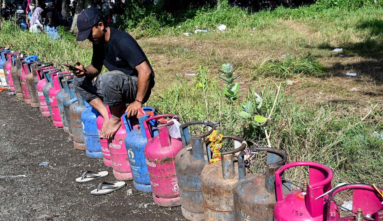 Antrean panjang warga terjadi di sejumlah titik distribusi untuk mendapatkan bahan bakar gas. Tampak dalam foto, seorang pria menunggu untuk membeli tabung gas di sebuah stasiun pengisian dan pembelian LPG setelah banjir bandang di Banda Aceh pada Rabu 17 Desember 2025. (CHAIDEER MAHYUDDIN/AFP)