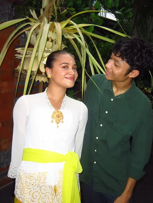 Aksesori berupa bros emas besar menghiasi bagian dada, menambah kesan formal dan tradisional. Kebaya putihnya memiliki detail renda di bagian lengan dan bawah, yang berpadu serasi dengan kamen (kain bawahan) berwarna kuning bermotif, senada dengan selendang. (Liputan6.com/IG/@auroraribero)