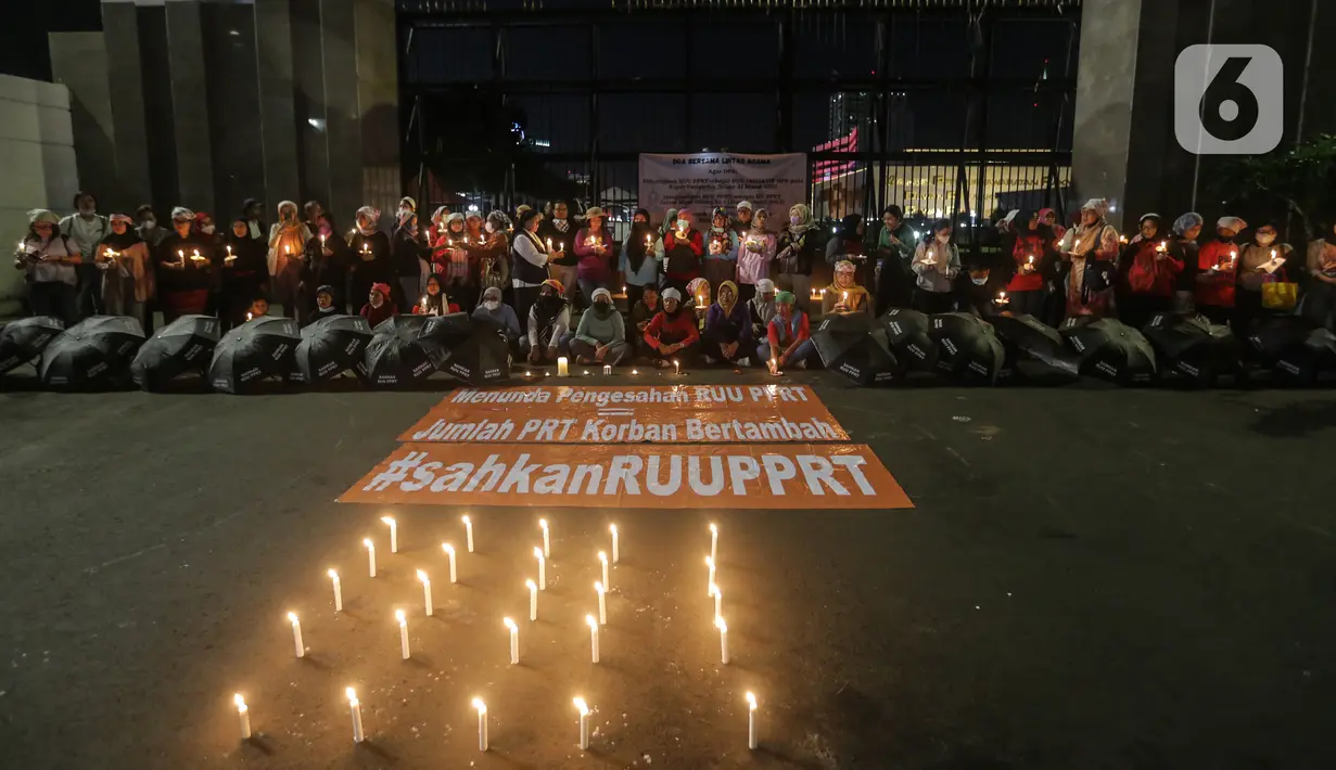 Massa menggelar aksi dengan membawa lilin dan doa bersama lintas agama di depan Gedung DPR, Jakarta, Kamis (16/3/2023). Dalam aksinya, mereka menuntut agar pimpinan DPR menetapkan RUU PPRT sebagai RUU INISIATIF DPR di Rapat Paripurna pada Selasa, 21 Maret 2023 mendatang. (Liputan6.com/Johan Tallo)