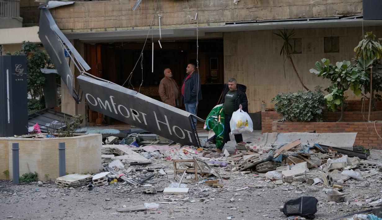 Militer Israel belum dapat menjelaskan siapa atau apa yang menjadi sasaran dalam serangan yang menghancurkan Comfort Hotel. Tampak dalam foto, seorang pria membawa barang-barangnya saat meninggalkan hotel yang rusak akibat serangan udara Israel di Hazmieh, sebelah timur Beirut, Lebanon, Rabu 4 Maret 2026. (AP Photo/Hussein Malla)