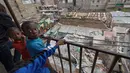 Anak kecil mengamati lokasi runtuhnya bangunan lima lantai di daerah permukiman di ibu kota Kenya, Nairobi, Minggu (4/6). Pihak berwenang menyebutkan, 30.000 hingga 40.000 gedung, yang dibangun tanpa izin di ibukota itu, berbahaya. (AP Photo/Ben Curtis)